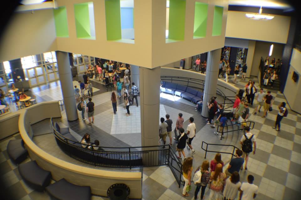  wide angle pic of class change in the main lobby of a high school